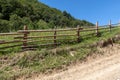 Old wooden fence along the dirt rural road Royalty Free Stock Photo