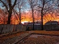 Old wooden fence in the backyard of a house with a view of a magical, colorful sunset