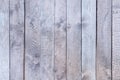 Old wooden fence with faded light gray wood. Smooth vertical boards. Blank background.