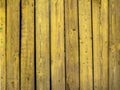Old wooden fence made of boards painted with yellow paint Royalty Free Stock Photo