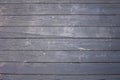 old wooden fence of painted boards with gray peeling paint with cracks and scratches. horizontal lines. rough surface texture Royalty Free Stock Photo