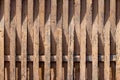 Old wooden fence with rails that intertwine with each other and peeling paint