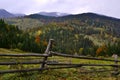 Rural landscape in the mountains with yellow trees and old wooden fence Royalty Free Stock Photo