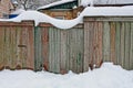 Old wooden fence with a wicket under white snow Royalty Free Stock Photo