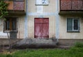 Old wooden fire door painted with red paint on a background of an old white tiles and windows of an old house Royalty Free Stock Photo