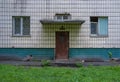 Old wooden fire door painted with red paint on a background of an old white tiles and windows of an old house Royalty Free Stock Photo