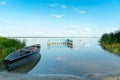 An old wooden fishing boat docked on a deserted sandy beach. View of a quiet and calm lake without ripples on the water. Royalty Free Stock Photo