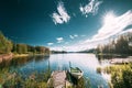 Old Wooden Fishing Boat Moored Near Pier In Summer Lake Or River. Beautiful Summer Sunny Day Or Evening. Swedish Nature