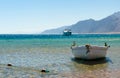 Old wooden fishing boat in the sea against the backdrop of the high rocky mountains in Egypt Dahab Royalty Free Stock Photo