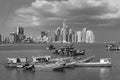 Old wooden fishing boats in front of the skyline of panama city panama in black and white