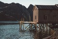 Old wooden fishing houses near the lake against the background of the mountains. Norway, Europe. Copy space. Can use as Royalty Free Stock Photo