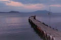 Old wooden fishing pier goes into the sea on sunset. Resort city Novyi Svet, Crimea Royalty Free Stock Photo