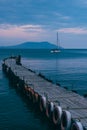 Old wooden fishing pier goes into the sea on sunset. Resort city Novyi Svet, Crimea Royalty Free Stock Photo