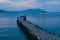 Old wooden fishing pier goes into the sea on sunset. Resort city Novyi Svet, Crimea Royalty Free Stock Photo