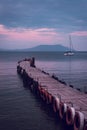 Old wooden fishing pier goes into the sea on sunset. Resort city Novyi Svet, Crimea Royalty Free Stock Photo