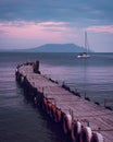 Old wooden fishing pier goes into the sea on sunset. Resort city Novyi Svet, Crimea Royalty Free Stock Photo