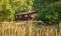 Old Wooden Forest farm house with a green meadow on summer day. Lone cabin in the woods of British Columbia Canada Royalty Free Stock Photo