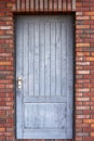 Old wooden front door of a red brick house Royalty Free Stock Photo