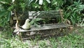 Old wooden garden bench and bird sculpture on the lawn Royalty Free Stock Photo