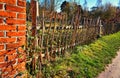 Old wooden garden fence on a brick wall Royalty Free Stock Photo