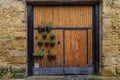 Old wooden gate with flower pots in an old stone house facade in Olite, Spain Royalty Free Stock Photo