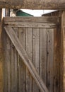 Old wooden gate leading to the courtyard. A stripped door in a country house.