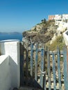 Old wooden gate with a picturesque view of coastal cliffs and sea. Santorini, Greece.