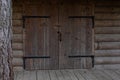 Old wooden gate of a rustic barn. Wooden gate with metal hinges, padlock and wooden latch. Entrance to an old rural village shed Royalty Free Stock Photo