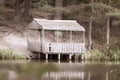 Old wooden gazebo on the shore of the lake in the photo in retro style Royalty Free Stock Photo