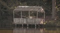 Old wooden gazebo on the shore of the lake in the photo in retro style Royalty Free Stock Photo