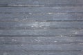 Old wooden gray fence made of planks with peeling paint, cracks and white spots close up. horizontal lines. rough surface texture Royalty Free Stock Photo