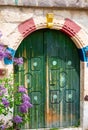 Old wooden green entrance door, view from the street