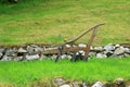 Old wooden hand plough in the green grass