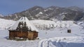 The old wooden hexagonal Altai house - ail in a snow-covered valley.