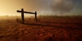 Wooden horse hitch post in desert at sunset with cloudy sky.