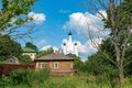 Russia, Uglich, July 2020. Wooden dwelling house against the background of the blue sky and the domes of the Orthodox monastery.