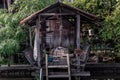 Old wooden house at alongside of canal and there is a large tree covering the house, There is one dog which is sleeping and Royalty Free Stock Photo