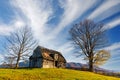 Old wooden house built on grassy hill against mountains Royalty Free Stock Photo