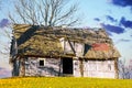 Old wooden house built on grassy hill against mountains Royalty Free Stock Photo