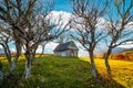 Old wooden house built on grassy hill against mountains Royalty Free Stock Photo