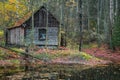 Old wooden house in a colorful autumn forest near lake Royalty Free Stock Photo