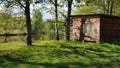 An old wooden house in the countryside by the lake with a mirror reflection in the water. green trees all around Royalty Free Stock Photo