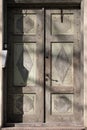 Old wooden house door. Weathered, aged, shabby, vintage entrance in sunshine with modern intercome system. Peeled off paint Royalty Free Stock Photo