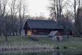 Old wooden house on the edge of forest near the lake in spring season. Fishing village. Traditional exterior in soviet or russian Royalty Free Stock Photo