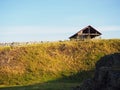 An old wooden house on a hill early in the morning. A ruined wooden building