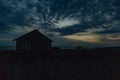 Old Wooden House by the Sea. Wonderful Sunset Landscape with a Dark Blue Sky Royalty Free Stock Photo