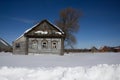 Old wooden house and snow drifts in winter in the village on a frosty Sunny day. Winter landscape. Russian village in winter Royalty Free Stock Photo