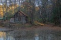 An old wooden house stands alone and neglected in a remote autumn forest. Royalty Free Stock Photo