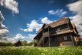 Croatian old wooden house with deep blue sky and clouds in motion in background Royalty Free Stock Photo