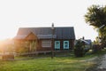 Old wooden house in village. National wooden farmhouse in Belarus. View of rustic ethnic house on sunset. Rural landscape Royalty Free Stock Photo